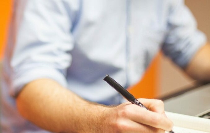 Man with a pen in his hand writing