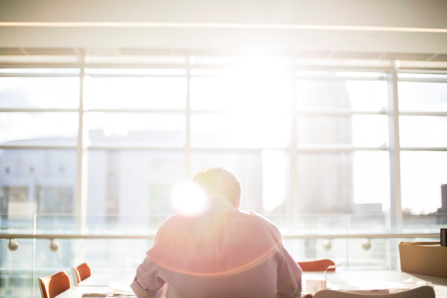 Man sat in an office with sunlight beaming through